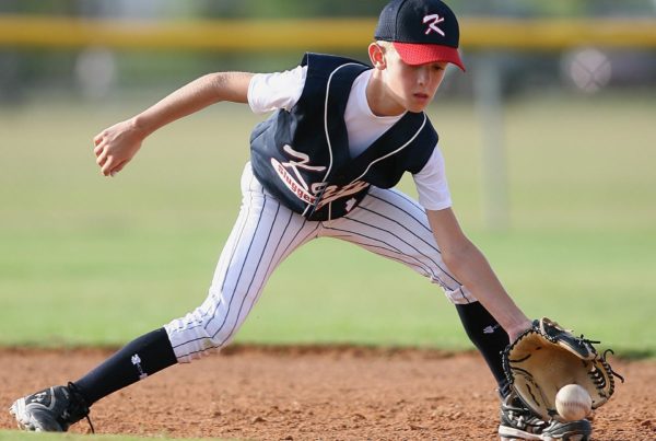 The Visual Aspects of Baseball | Little league baseball player fielding the ball | SureVision Eye Centers